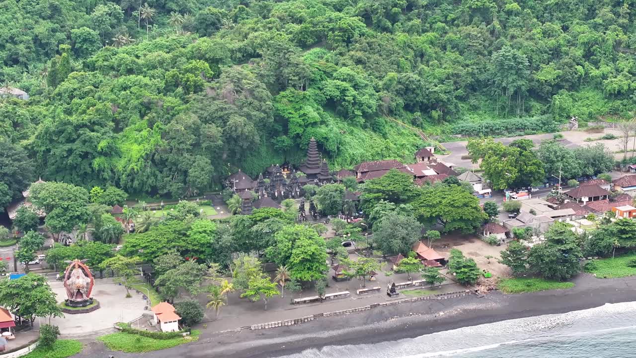 Hindu Temple complex and black sand beach in Bali, Indonesia. Pura Goa Lawah - drone