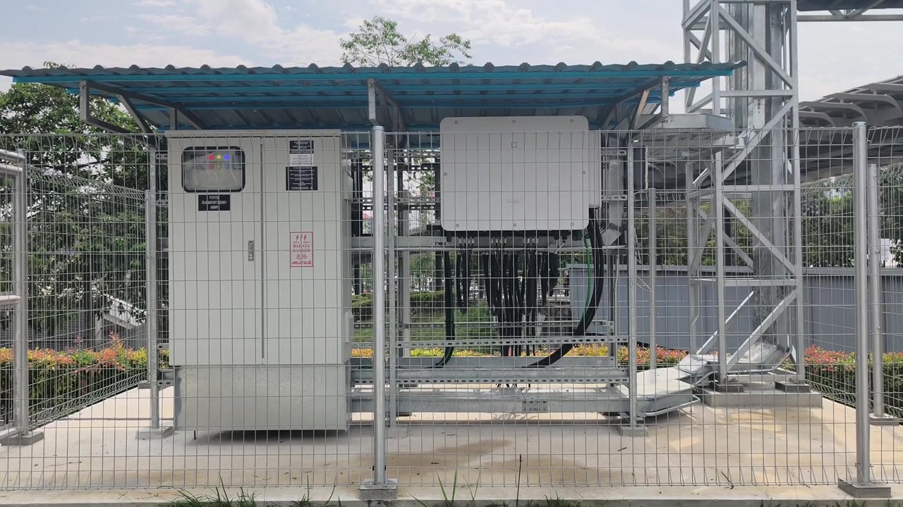 Eine große Solarwechselrichteranlage steht im Freien hinter einem Sicherheitszaun gesichert. Dieses Hochleistungssystem verarbeitet Energie, die von einer riesigen Solarmodulanlage gewonnen wird. Es unterstreicht fortschrittliche erneuerbare Energietechnologien
