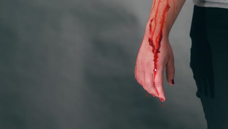 Girl-with-bloody-arm,-a-lot-of-blood-comes-out,-the-drops-fall-in-slow-motion