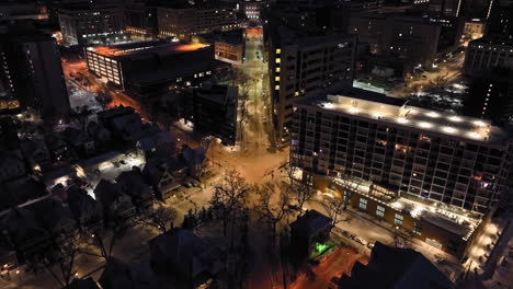 drone inclinándose sobre calles nevadas, revelando el capitolio del estado de wisconsin, noche en madison, estados unidos