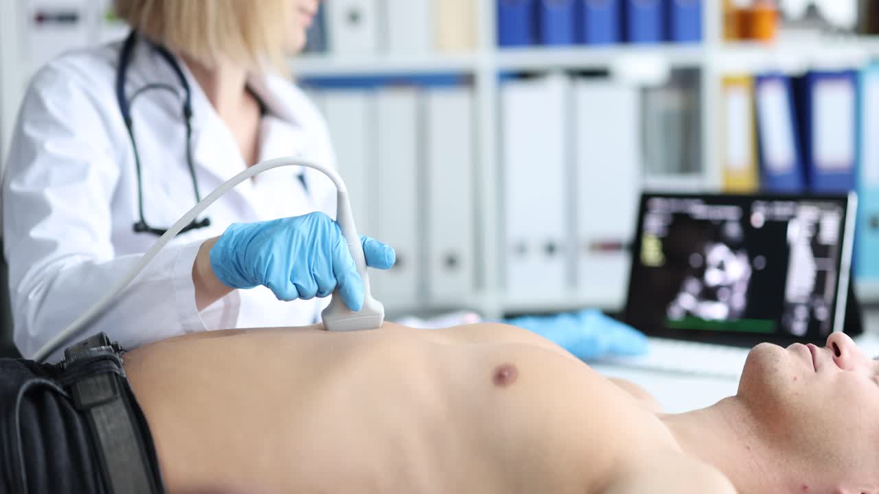 Doctor performing ultrasound examination on a patient's abdomen