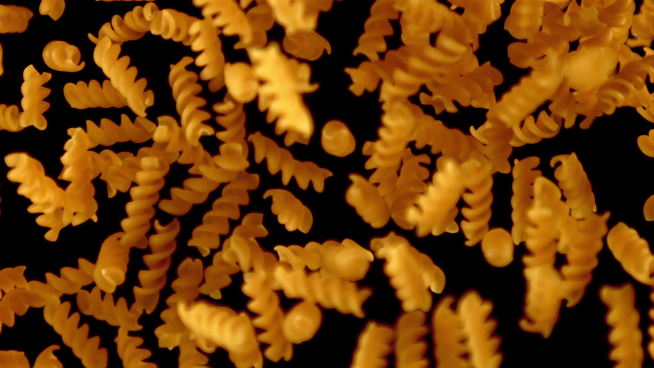 Massa Fusilli Crua Caindo em Super Câmera Lenta em Fundo Preto