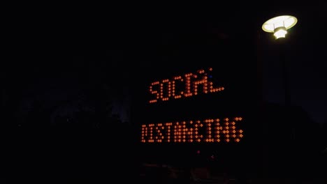 señal de mensaje cambiable portátil con distanciamiento social exhibido por luces led en la noche en sydney