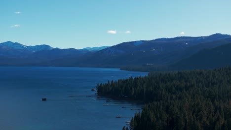 Drone-shot-panning-to-the-left-looking-down-at-the-tree-line-on-the-shore