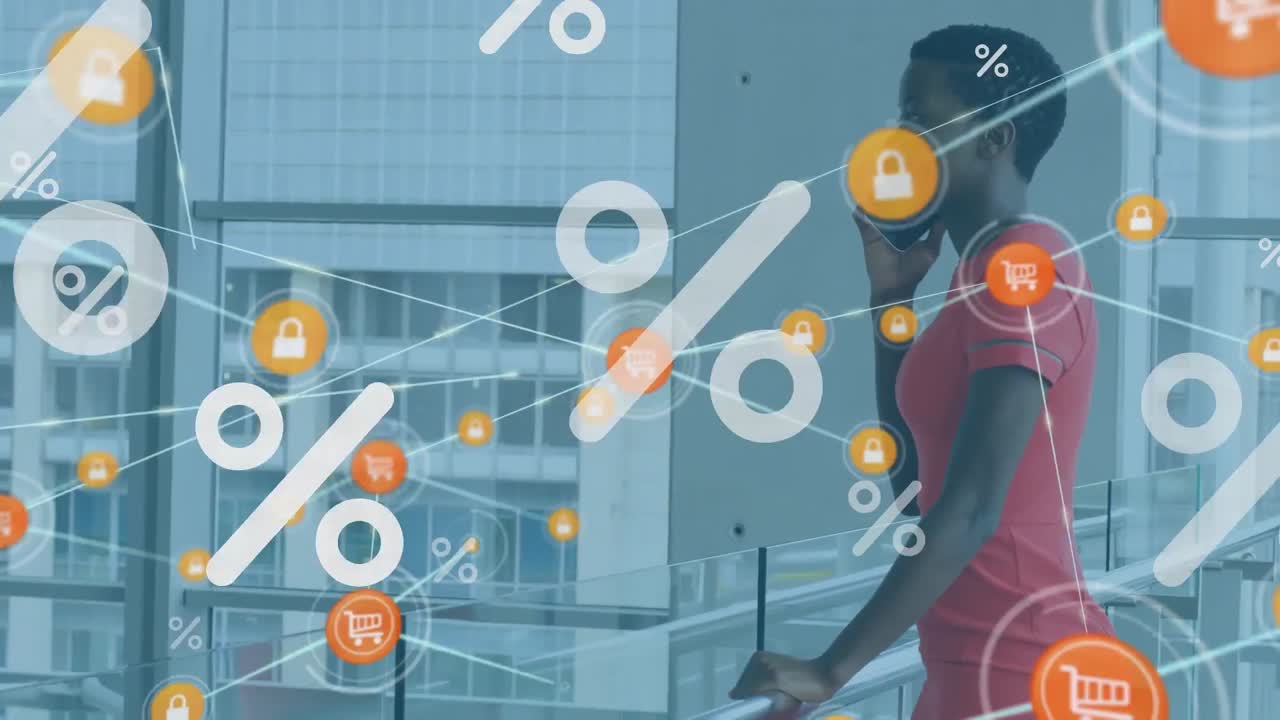 Animation von Prozentsymbolen über afroamerikanischer Geschäftsfrau, die im Büro am Smartphone spricht