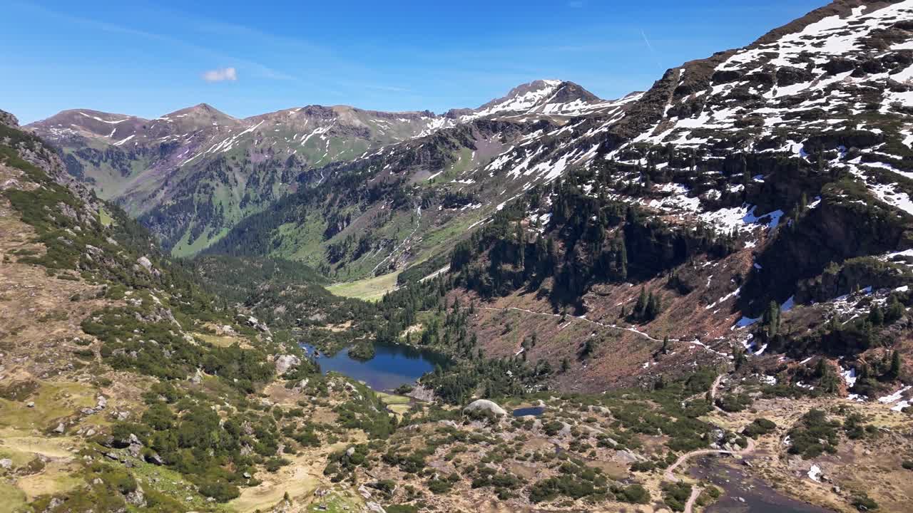 Murgsee nestled in the Swiss Alps, a serene alpine lake amid towering peaks, green valleys and patches of snow under a clear blue sky, untouched and picturesque, Switzerland