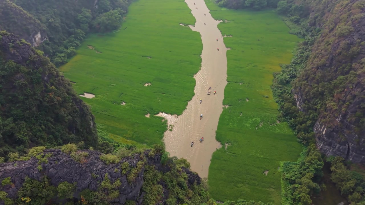 Cảnh quay trên không tuyệt đẹp về thung lũng sông Ninh Bình mang tính biểu tượng với những chiếc thuyền đi qua các khối đá karst hiểm trở và phong cảnh nhiệt đới.