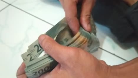 counting two thousand rupiah with indonesian money, with your east asian hand