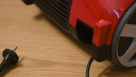 red vacuum cleaner on wooden floor