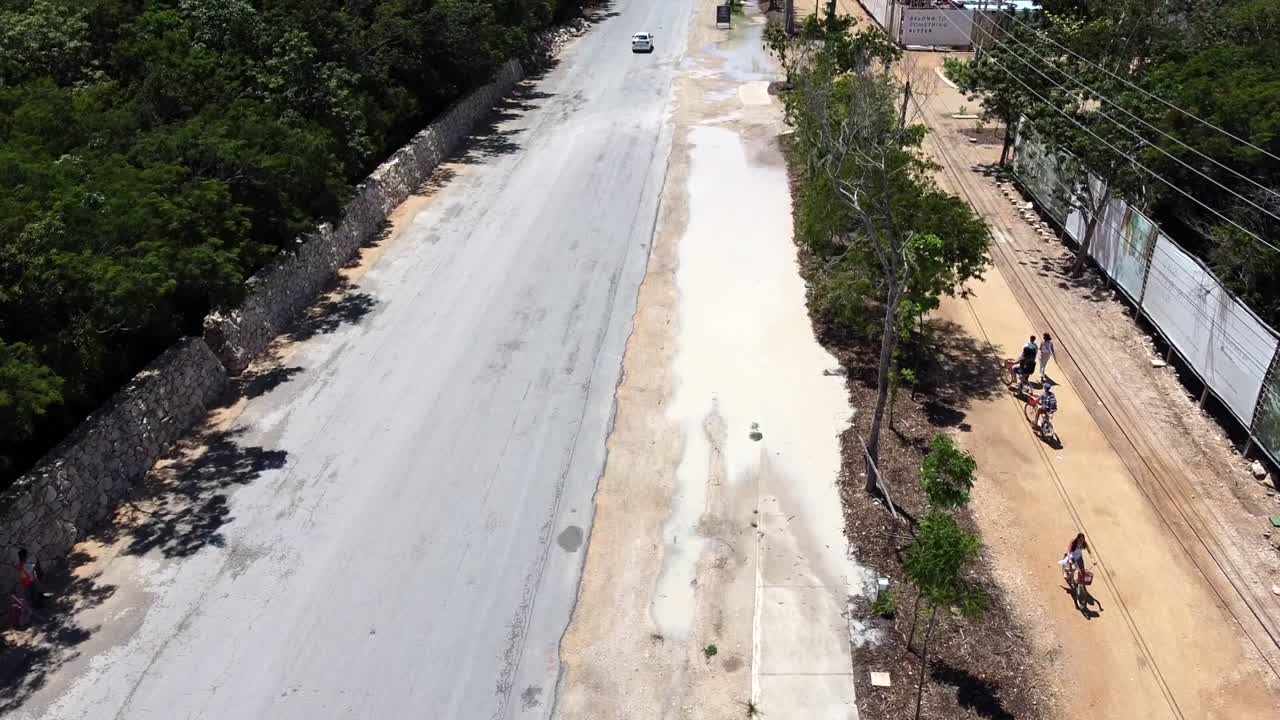 관광객들은 멕시코의 툴룸 호텔 구역을 향해 주요 도로에서 자전거를 타고