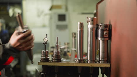 technician inspecting high-precision cutting tools in a manufacturing workshop setting