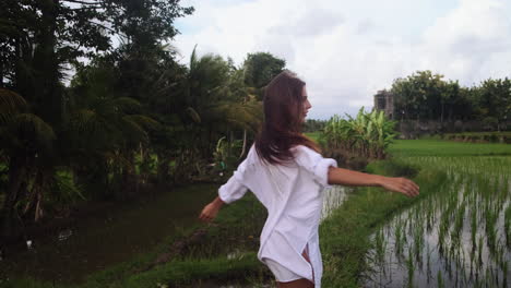 woman walking through rice paddies in bali
