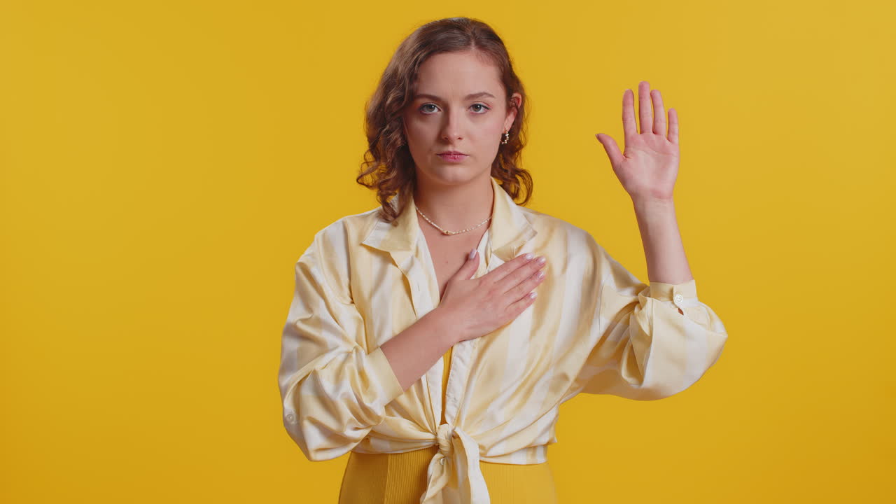 mujer levantando la mano para tomar el juramento prometiendo ser honesta y decir la verdad manteniendo la mano en el pecho