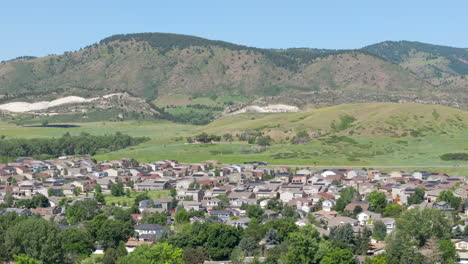 Pan-left-aerial-view-of-suburban-neighborhood-in-the-summer-with-renewable-and-green-rooftop-solar-panels-to-help-the-climate