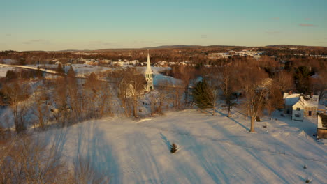 Malerische-Luftaufnahme-Einer-Charmanten,-Schneebedeckten-Kleinstadt-Bei-Sonnenuntergang