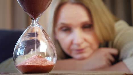 a woman looks at an hourglass 2