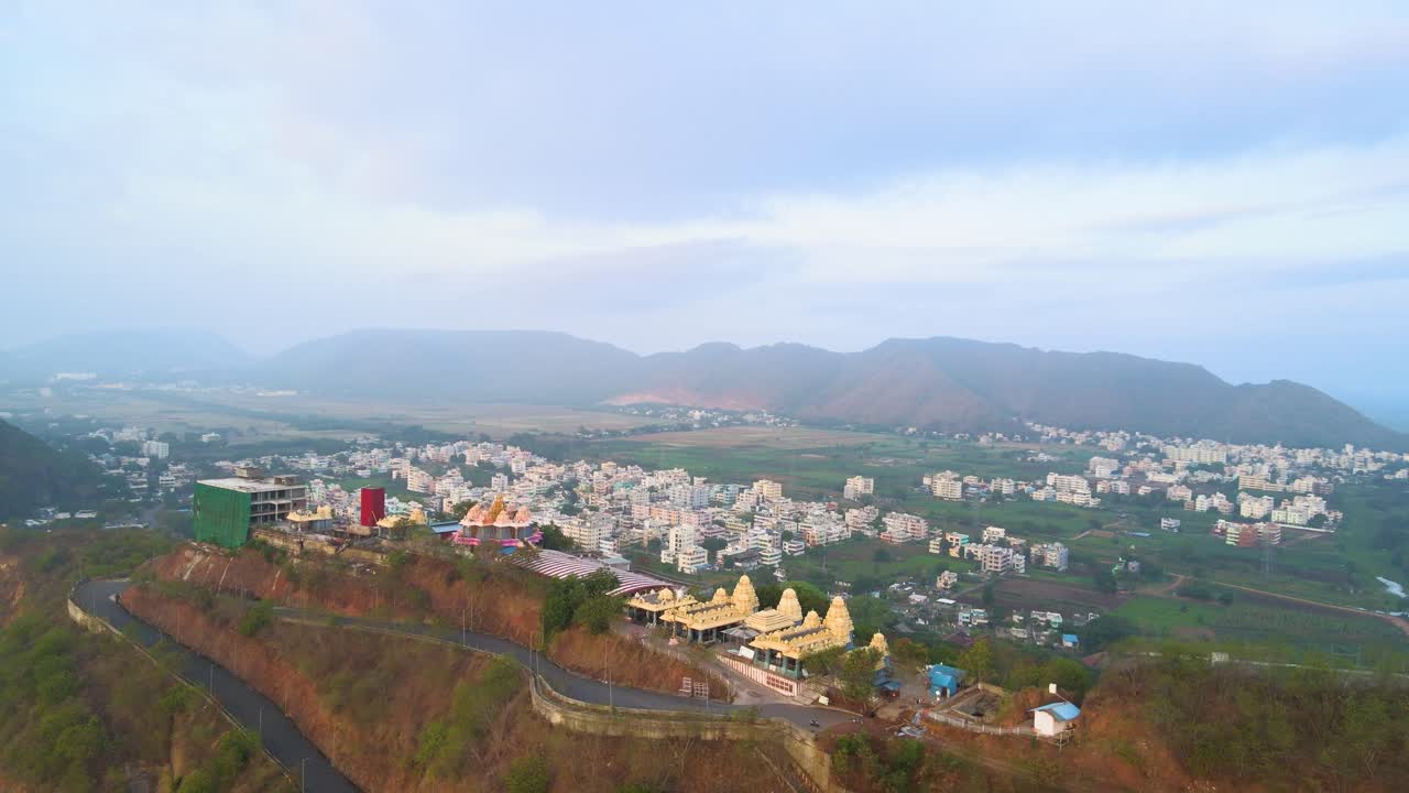 Majestic aerial drone shot of Vijayawada city during sunrise, with a view soaring above the scattered clouds.