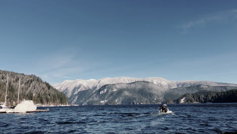 boat leaving deep cove dock towards mountains