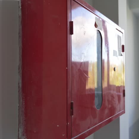 red locker box with firefighting equipment inside. white interior of newly-constructed office premises