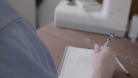 man sketching gown for sewing