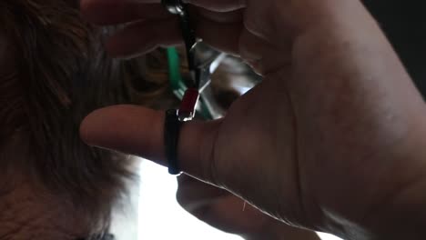 cutting the back of someone's neck with scissors - a comb