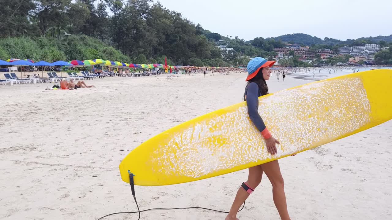 열대 해변 에서 서프보드 를 들고 있는 여자