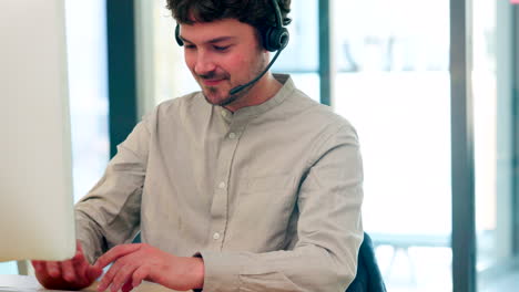 Male-call-center-agent-with-a-headset-working