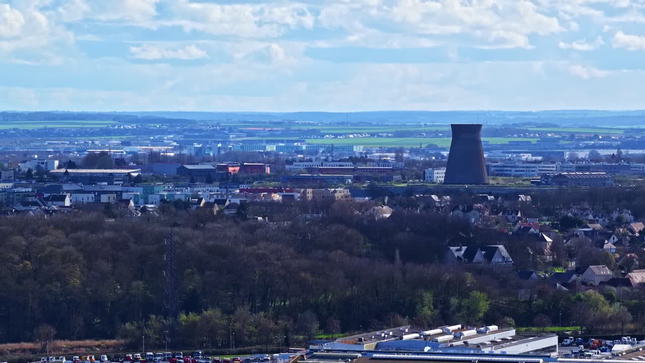 Stadtansicht von Le Havre mit einem Kühlturm, Wohngebäuden und Industrieanlagen.
