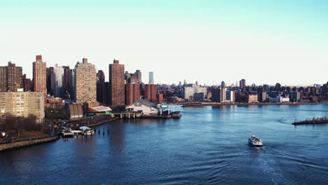 ferry on the east river, springtime evening in yorkville, ny, usa - descending, drone shot