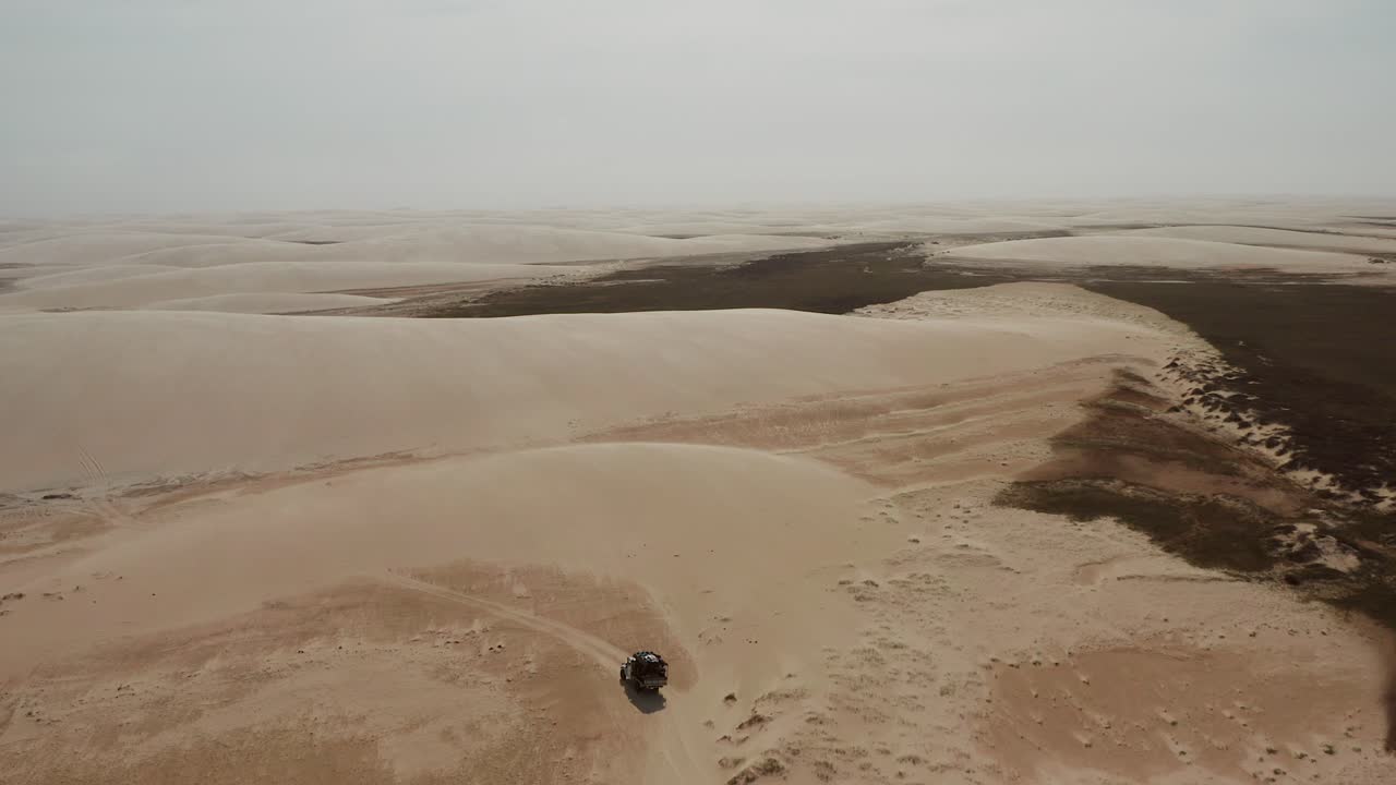 Off-Road Vehicle in a Desert Landscape with Sand Dunes