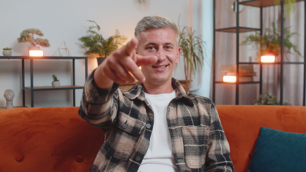 Glad tilfreds mand smiler og peger på kameraet, vælger heldig vinder, indikerer inviterende godkendelse