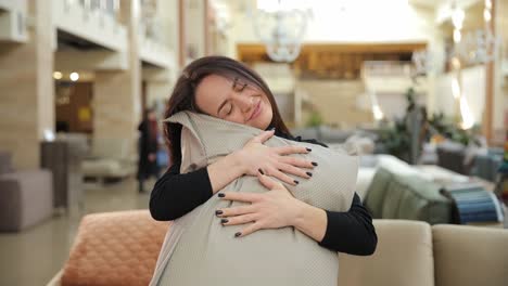 Woman embracing a pillow in a furniture store