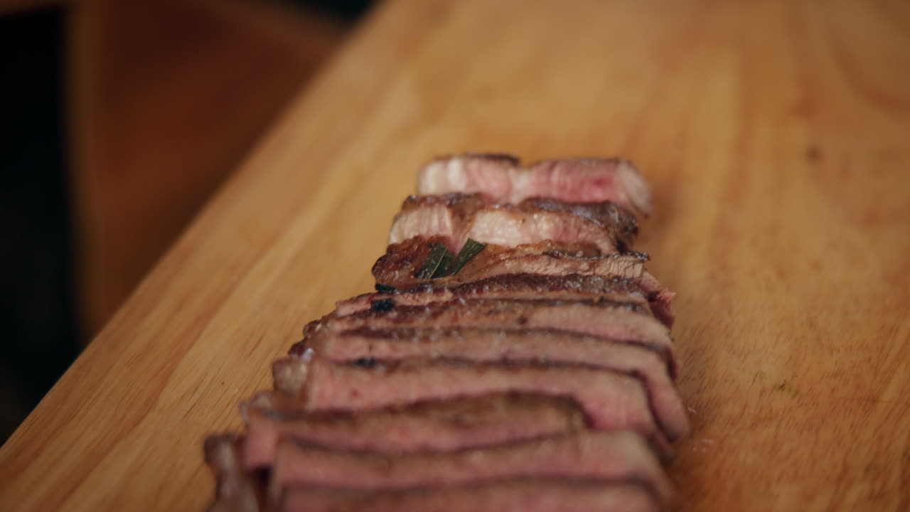 bistec cocido en rodajas en una tabla de cortar de madera