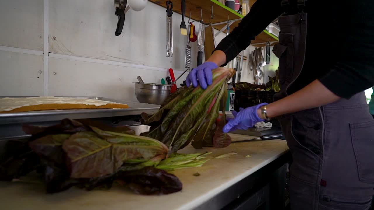 Addetto alimentare che raccoglie verdure su un tagliere