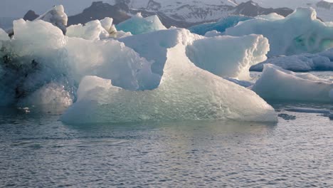 Chunk-of-ice-moving-in-cold-glacier-lagoon-Jökulsárlón,-Iceland