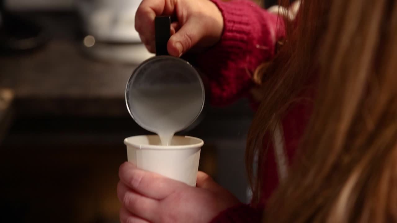 una mujer preparando un latte.