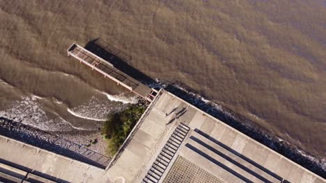 group of people walking along rocky promenade beside atlantic ocean in buenos aires