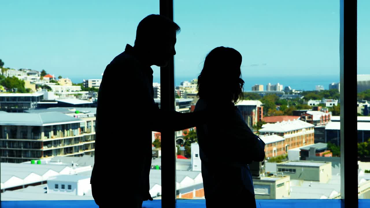 silueta de una pareja interactuando entre sí cerca de la ventana