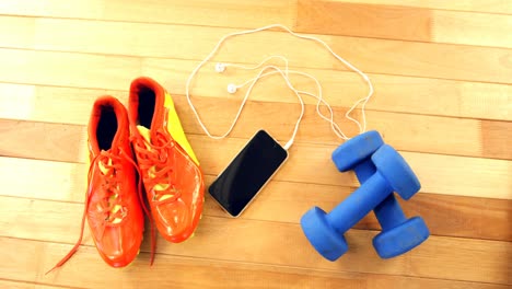 Mobile-phone-with-headphones,-shoes-and-dumbbells