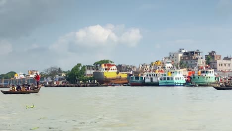 unrecognizable people crossing buriganga river in wooden boat in dhaka, bangladesh