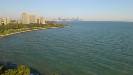 Drone-Volando-Hacia-Atrás-Revela-Hermoso-Parque-De-La-Ciudad-En-Chicago,-Horizonte-En-La-Distancia