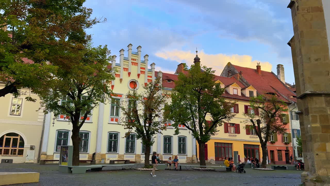 Sibiu, Romania, 17 July 2025: Colorful old houses in Sibiu. Historic colorful buildings in the old town of Sibiu with people walking in the square
