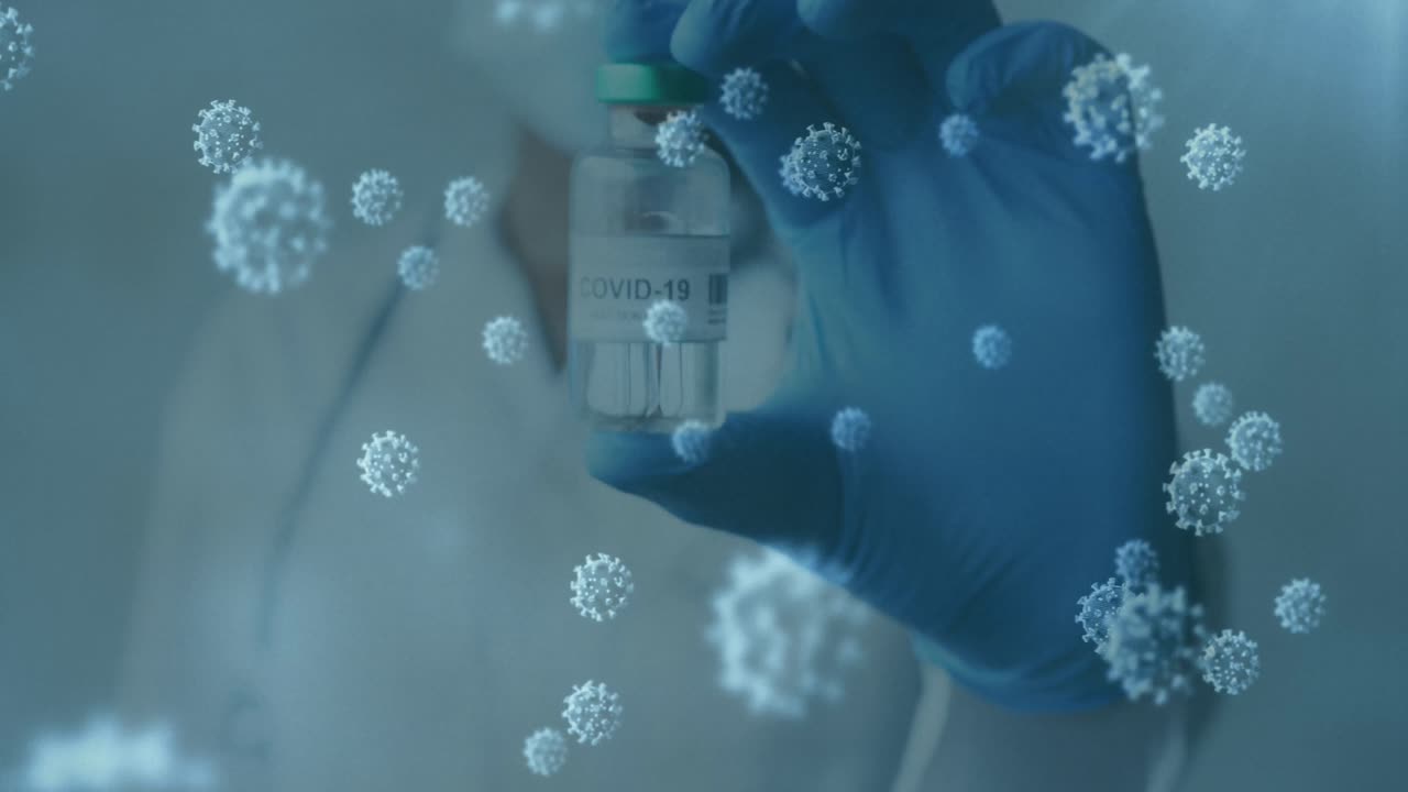 animación de células de covid 19 y un médico enmascarado con guante sosteniendo la vacuna