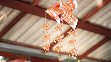 decorative fish mobile swaying under a roof