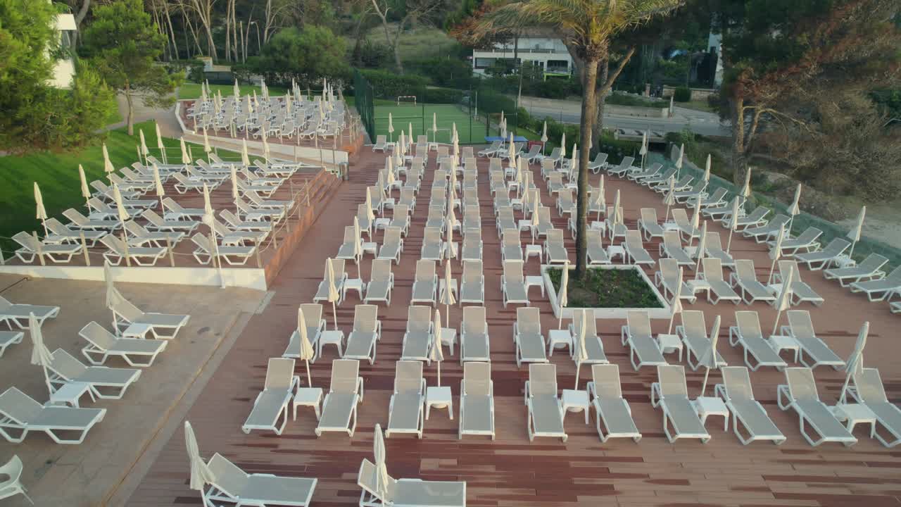 drone descubriendo numerosas sillas de sol en un hermoso hotel con piscinas en palma mallorca, españa