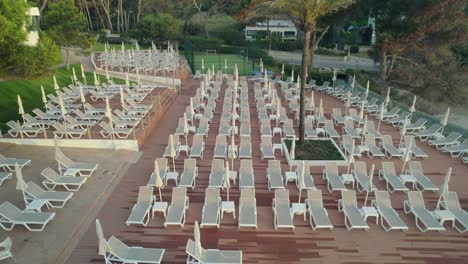 drone uncovering numerous sun loungers at a beautiful hotel with pools in palma mallorca, spain