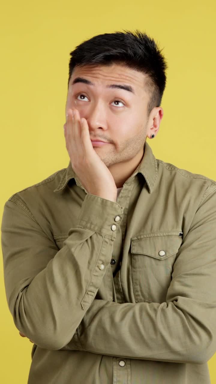A bored man in front of a yellow background
