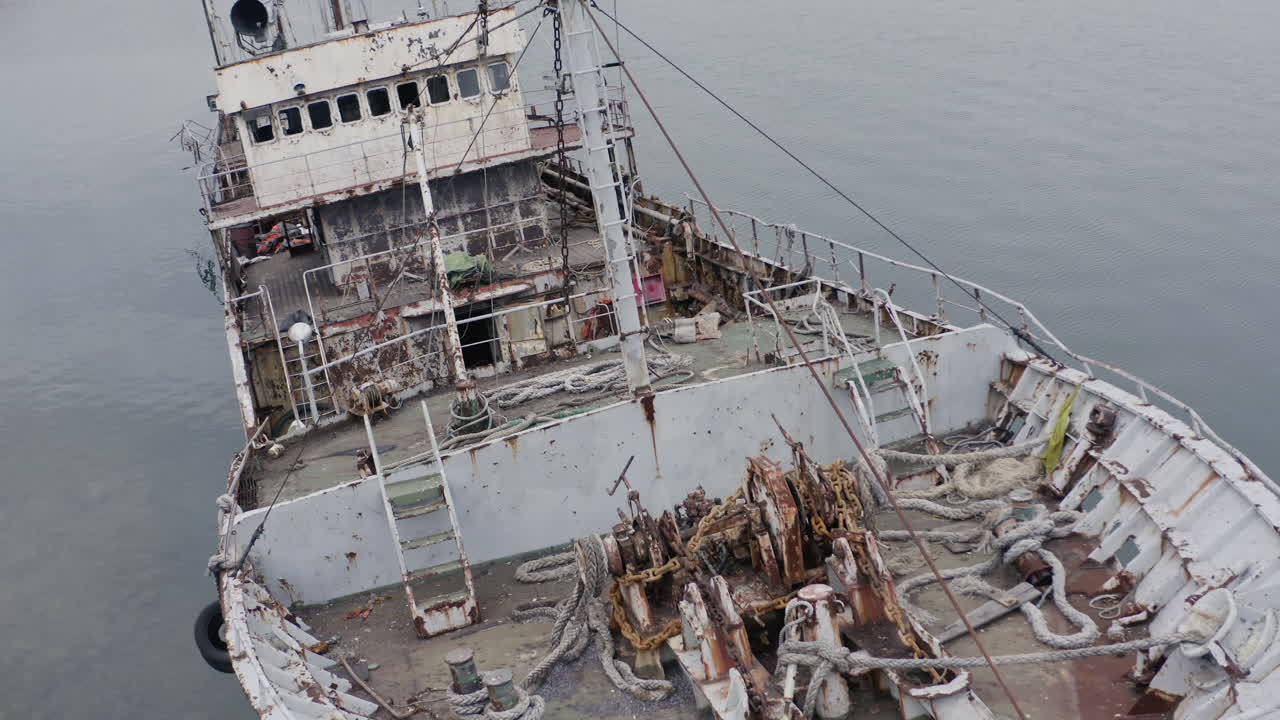 흐린 흐린 날 해안 근처에 정박한 녹슨 회색 반 침수 난파선