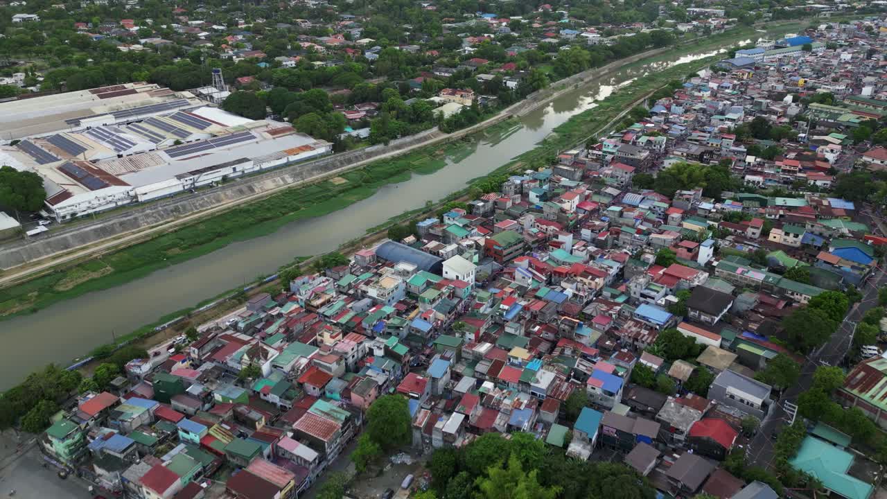 Aerial overview of dilapidated rooftops and polluted river along Marikina City, Luzon, Philippines.