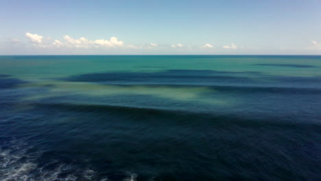 Aerial-drone-footage,-coastline-with-black-rocks-in-Bali